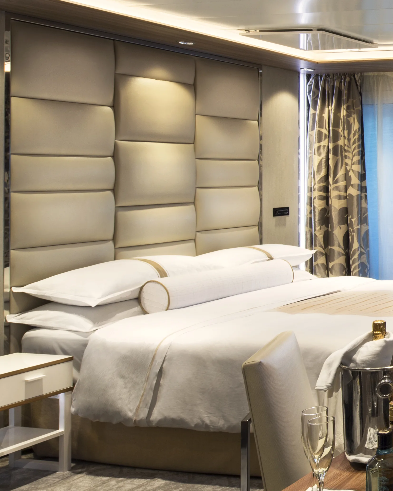 Luxury bedroom suite with upholstered headboard, king bed, premium linens, and modern ambient lighting.