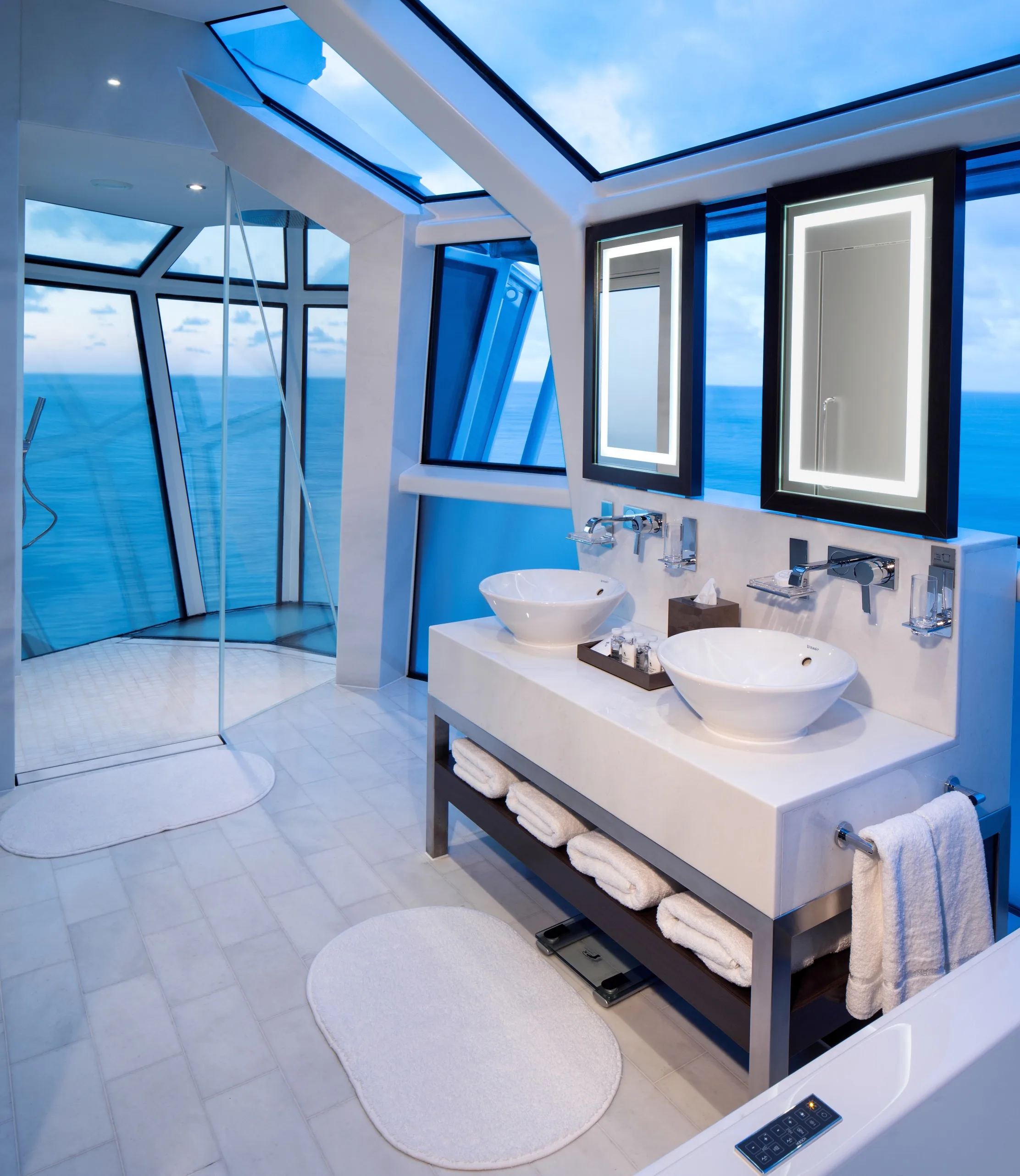 Luxury bathroom with double vanity, walk-in shower, skylights, and panoramic ocean views.