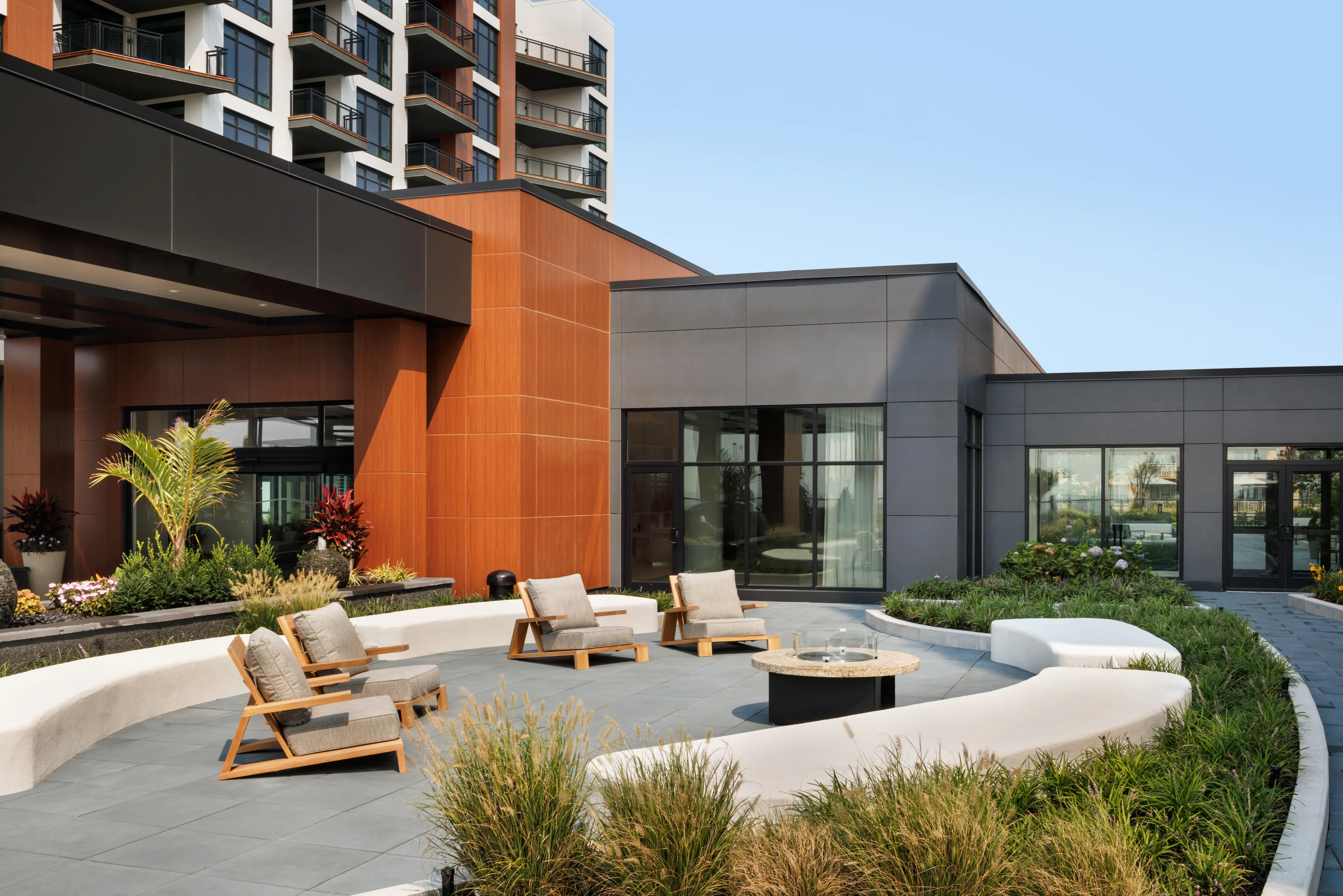 Modern apartment courtyard with fire pit and landscaped seating area
