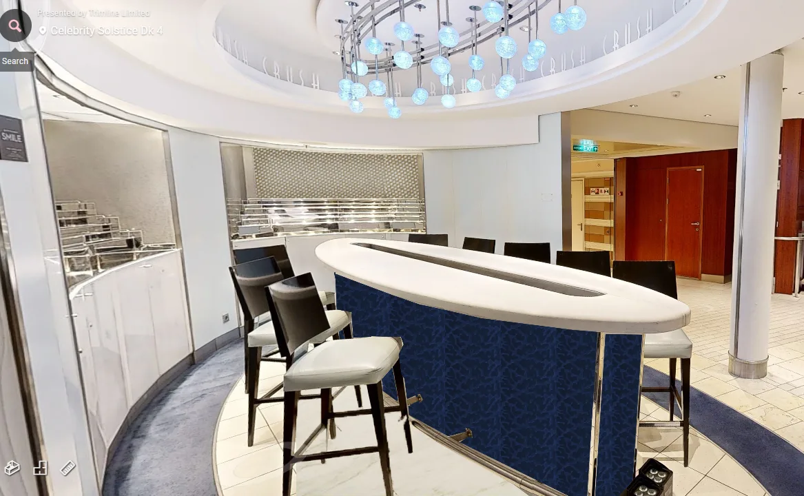 Modern cruise ship bar with curved counter, blue accents and overhead globe lighting