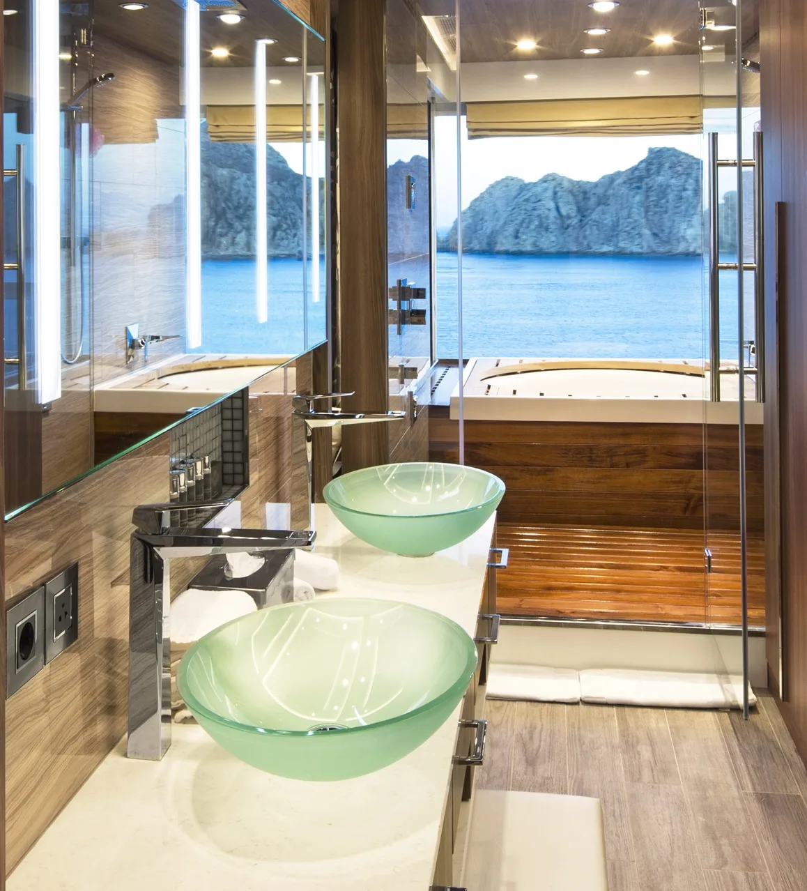 Luxury cruise ship bathroom with double vessel sinks, soaking tub and ocean view