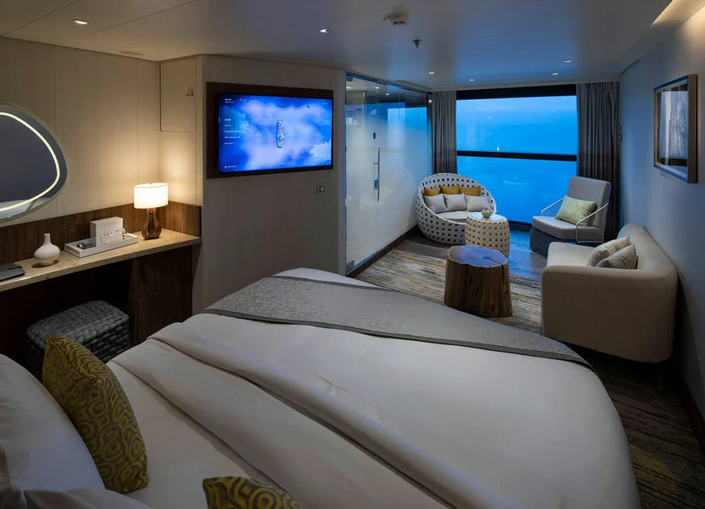 Ocean-view suite with bed and sitting area.