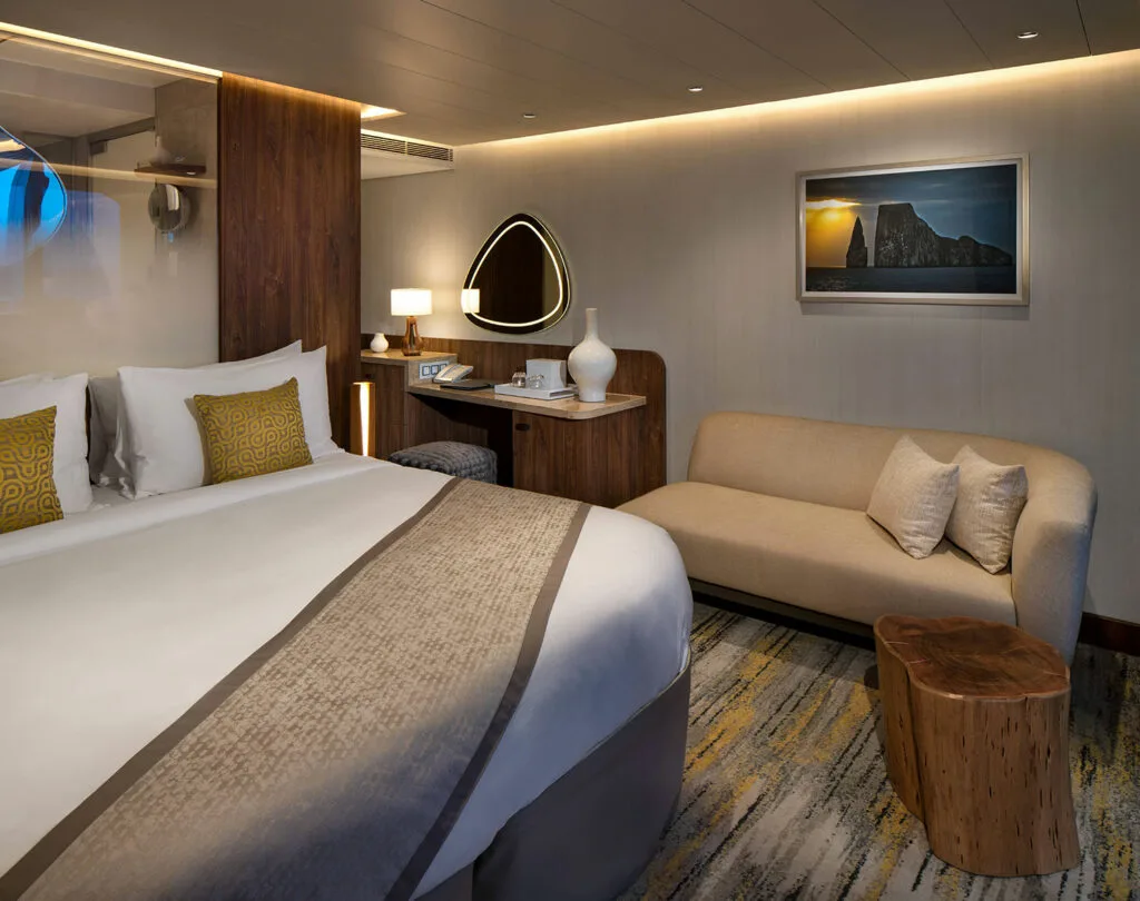Flora suite bedroom with sofa and wood accents.