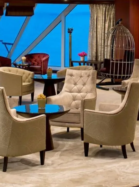 Luxury cruise ship lounge with contemporary seating, floor-to-ceiling windows and ocean views