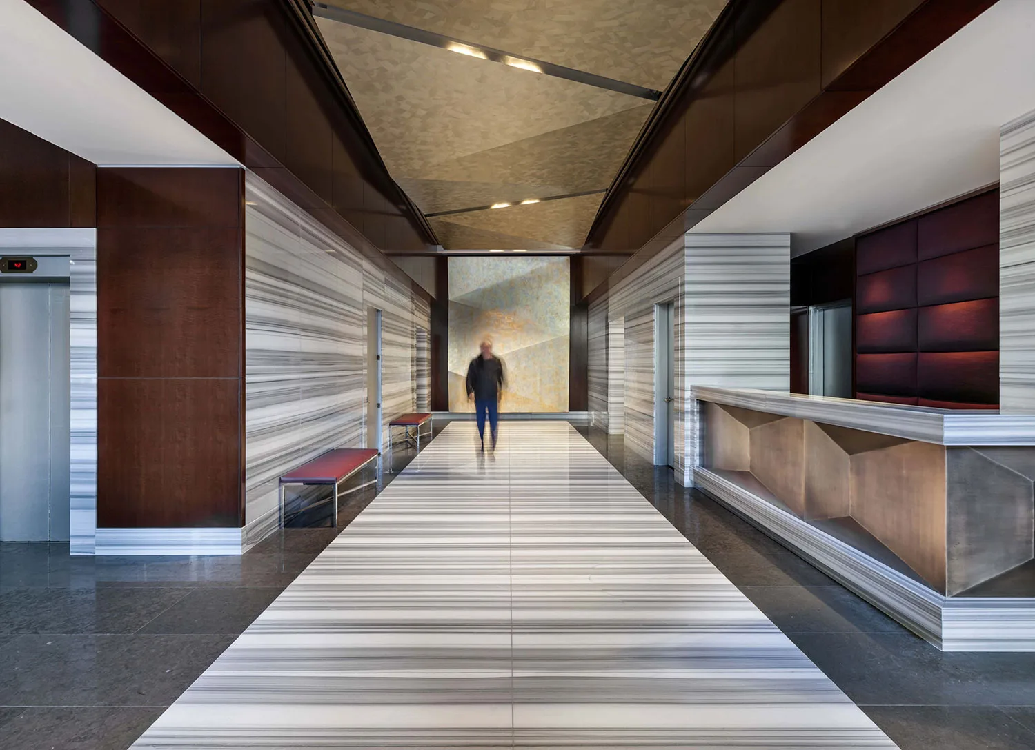 Luxury apartment lobby with marble floors, wood paneling and reception desk