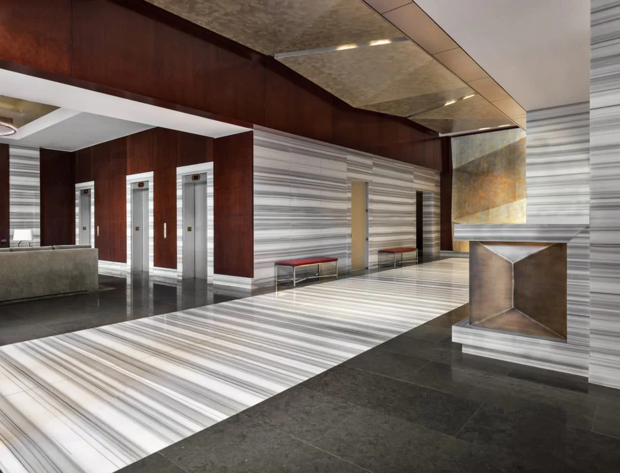 Contemporary apartment lobby with elevators and marble flooring